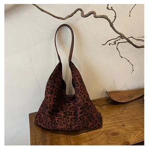 Detailed view of leopard print tote bag with soft fabric texture on wooden table