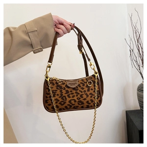 Detail of leopard print handbag with premium leather trim and golden metal chain strap