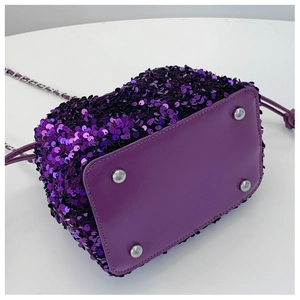 Dettaglio della borsa a secchiello con paillettes viola con base in pelle e piedini argentati