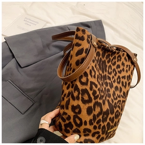 Detail view of leopard print bucket bag featuring premium suede texture and leather straps