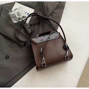 Detail of vintage brown leather backpack with houndstooth flap and silver hardware