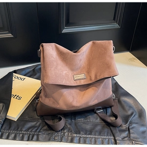 Detailed view of the large brown suede flap backpack with vintage leather stitching