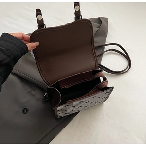Detail of the vintage dark brown backpack showing the main compartment and zipper pocket
