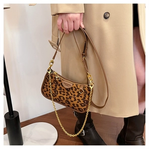 Detail of leopard print suede baguette bag with brown leather trim and gold chain strap