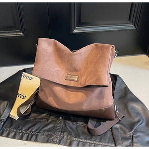 Detailed close-up of retro brown suede tote bag featuring metallic MOROMORO brand plate