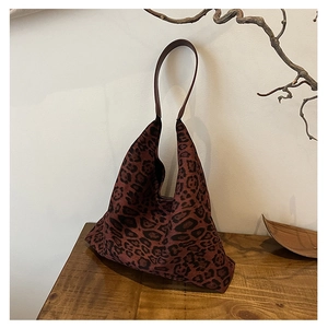 Close-up of leopard print canvas tote bag on a wooden table with natural aesthetic decor
