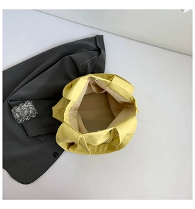 Detail view of yellow leather tote bag interior with zip pocket and textile lining