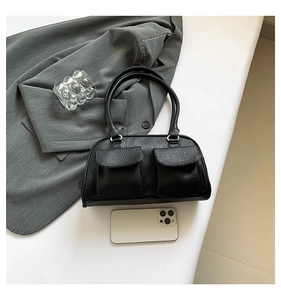 Top view of black vintage textured leather handbag with front pockets and office accessories