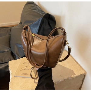 Detailed macro view of the vintage brown PU leather bucket bag with metallic zipper hardware
