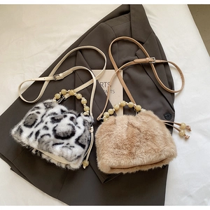 Detail view of faux fur bucket bags with leopard print and resin bead handles