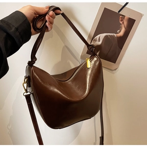 Detailed shot of dark brown hobo bag showing knot strap and metallic zipper closure