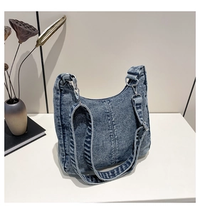Detail view of the durable double stitching and metal hardware on the denim hobo bag