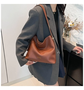 Brown matte leather hobo bag with wide shoulder strap and subtle gold lettering detail