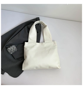 Detail of soft cream PU leather tote bag with natural grain texture and wide strap