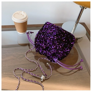 Dettaglio borsa a secchiello con paillettes viola, catena argento e chiusura a coulisse