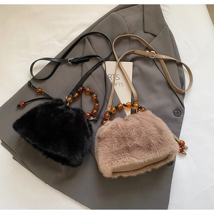 Close-up of leopard faux fur bucket bags with amber beaded handles and leather straps