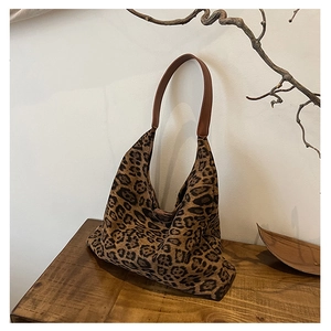 Detailed macro view of leopard print canvas fabric with brown faux leather handles