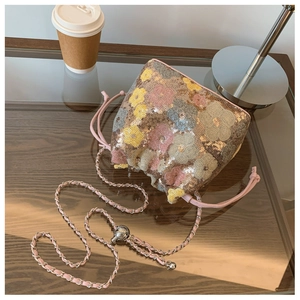 Dettaglio borsa a secchiello con paillettes e motivo floreale colorato con catena