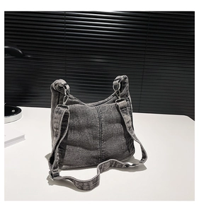 Close-up of vintage washed grey denim bag texture with bright silver metal hardware