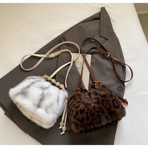 Detail of leopard print and white faux fur bucket bags with beaded leather strap accents