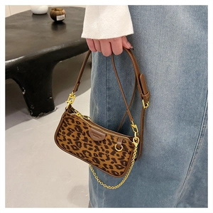 Detail of leopard print underarm bag with gold chain and premium brown leather trim