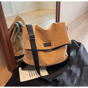 Detail view of large mustard yellow suede and black leather patchwork tote bag