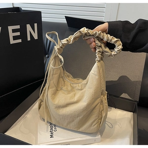 Detail van de beige hobo tas met geplooide scrunchie handgreep en zachte gerimpelde stof