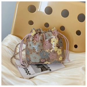 Dettaglio della borsa a secchiello di paillettes con ricami floreali e tracolla a catena