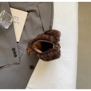 Detail of faux mink leopard bucket bag featuring amber beads and metal zipper closure