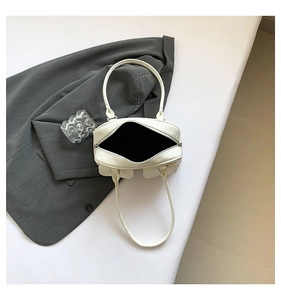 Detailed view of white lychee leather hobo bag with multiple utility pockets and top zipper