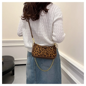Close-up of leopard print shoulder bag with gold chain and dark brown leather strap
