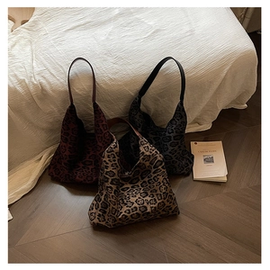 Detailed shot of three leopard print tote bags in dark red, charcoal grey and tan