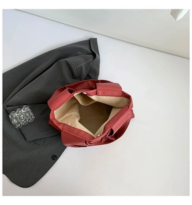 Detailed interior of brick red tote bag showing beige fabric lining and magnetic snap