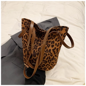 Detailed macro shot of the leopard print faux fur bucket bag with brown leather straps