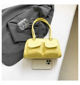 Macro shot of yellow leather texture and dual front flap pockets on a chic shoulder bag