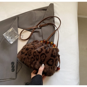 Detail of faux mink leopard bucket bag with amber beads and leather shoulder strap