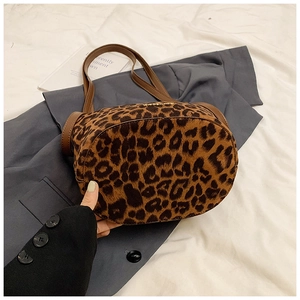 Detailed close-up of leopard print bucket bag with brown leather strap and gold logo