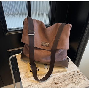Detail of cocoa brown suede tote bag with leather corners and silver metal buckle