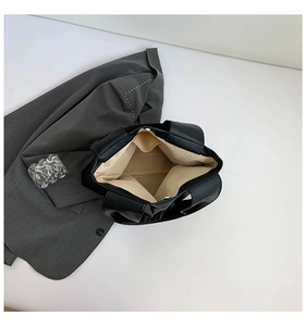 Macro view of interior storage in black pebble leather tote bag with secure magnetic clasp