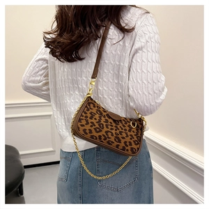 Detail showing leopard print shoulder bag with gold chain and brown leather strap on model