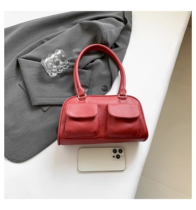 Macro detail of red vintage faux leather shoulder bag with dual front flap pockets