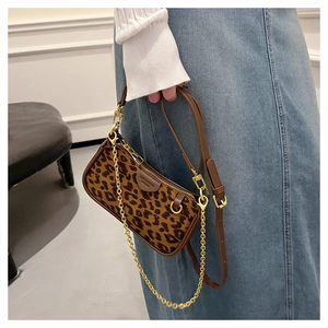 Close-up of leopard print baguette bag with brown leather trim and gold chain detail