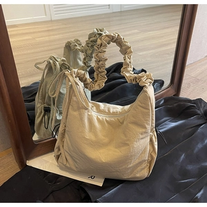 Detail van scrunchie-handvat en trekkoord op de beige nylon schoudertas dames