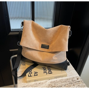Detail of large tote bag with khaki suede and black leather stitching design