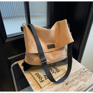 Macro shot of khaki suede tote bag with black leather base and wide strap details