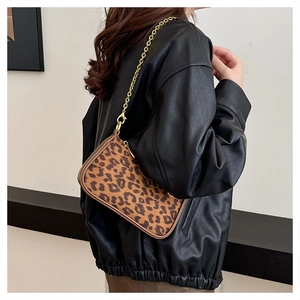 Close-up of leopard print shoulder bag with gold chain strap and leather piping edges