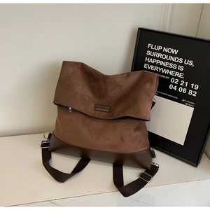 Detail of vintage brown suede tote with leather corners and wide shoulder strap