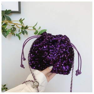 Dettaglio borsa a secchiello con paillettes viola e catena d'argento con sfera