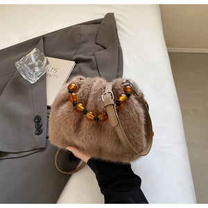 Detail of faux fur bucket bag with amber beads handle and adjustable leather strap