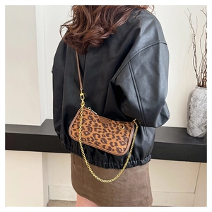 Close-up of leopard print shoulder bag with gold chain strap and brown leather detailing